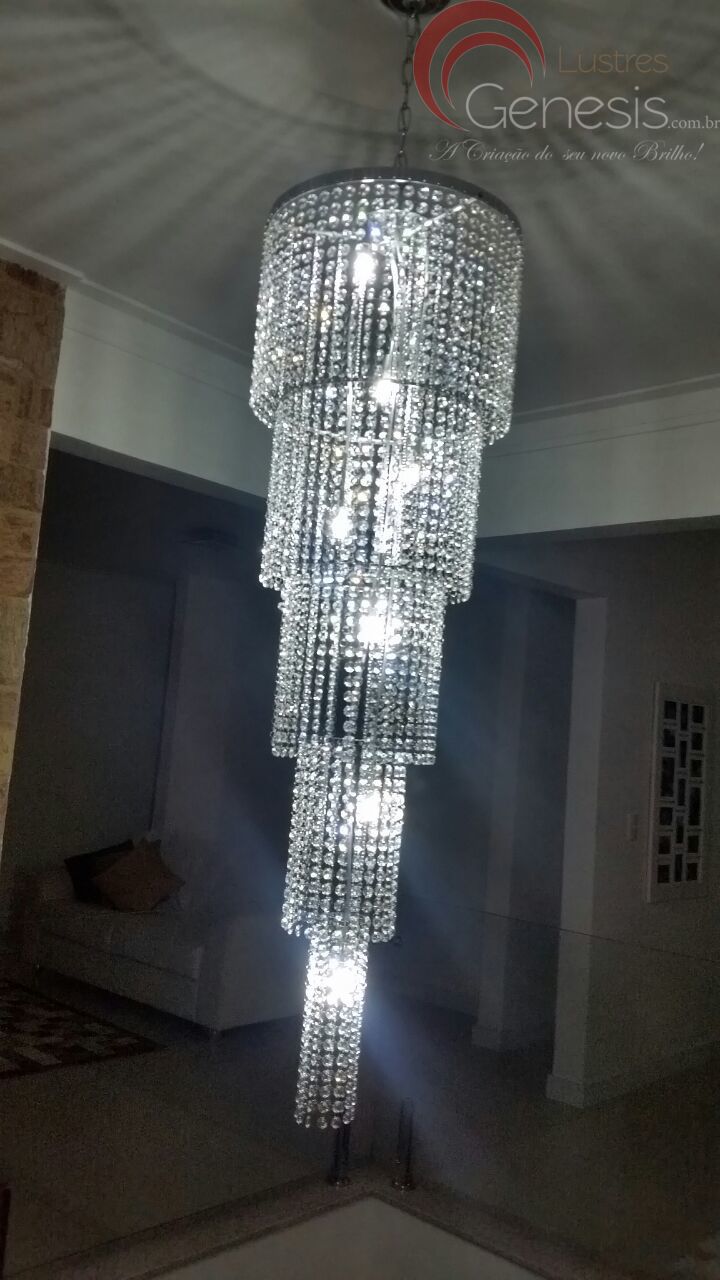 Lustre de Cristal Cascata para escadas e casas com pé direito duplo, com iluminação acesa, da marca Lustres Gênesis. Lustres Gênesis loja online de Lustres e Iluminação Decorativa